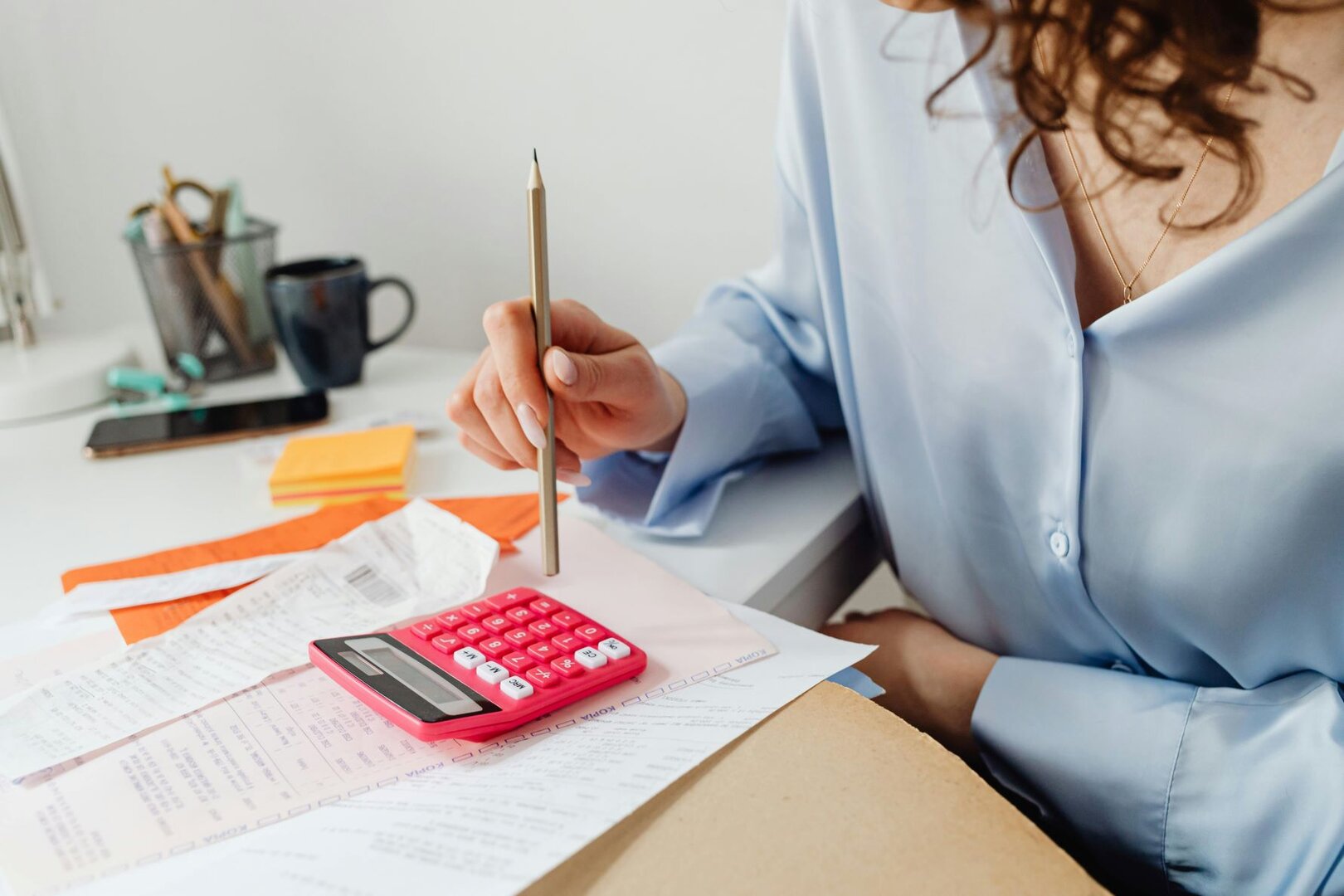 Woman works with a calculator and pencil