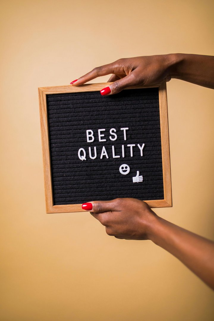 Hands holding a sign saying “Best Quality”